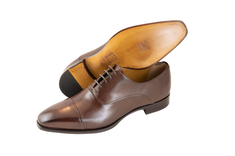The classic men's leather Oxford shoe available in brown and black. Made from pure calf leather by our shoe artisans in Italy. Its sleek, elongated shape adds a modern touch to a classic design.